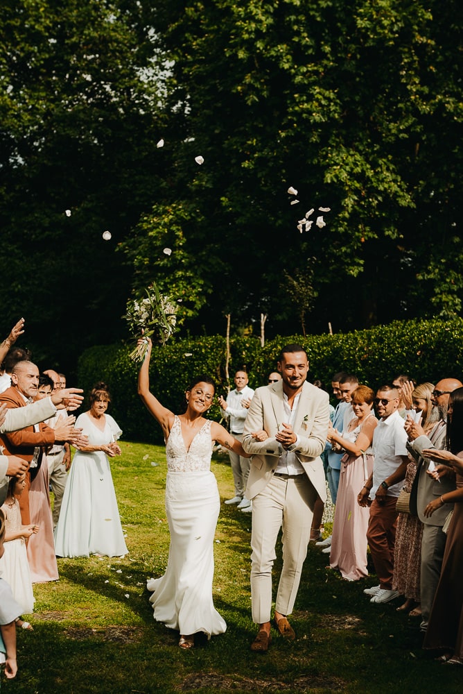 Photographe Gironde & Bordeaux, je photographie votre mariage comme ici la sortie des mariés lors de leur cérémonie laïque dans le jardin du domaine de mariage.