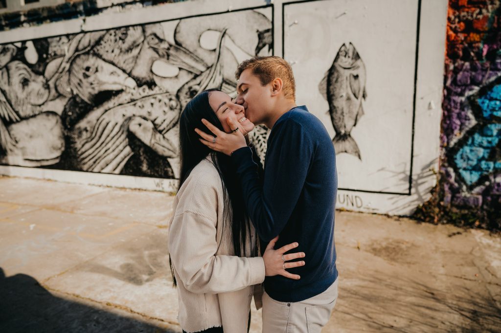 un jeune couple qui se font des bisous le temps d'une balade sur Bordeaux lors d'une séance photo