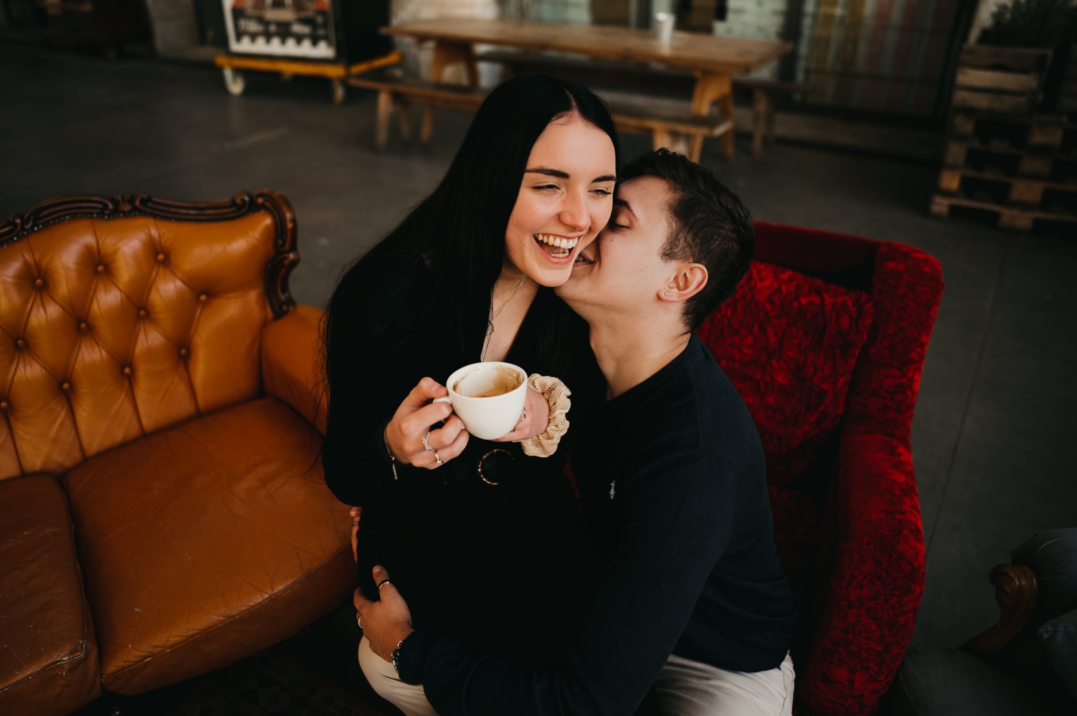 un jeune couple, lors d'une séance photo couple à Bordeaux qui prennent un café en amoureux tout en s'enlaçant
