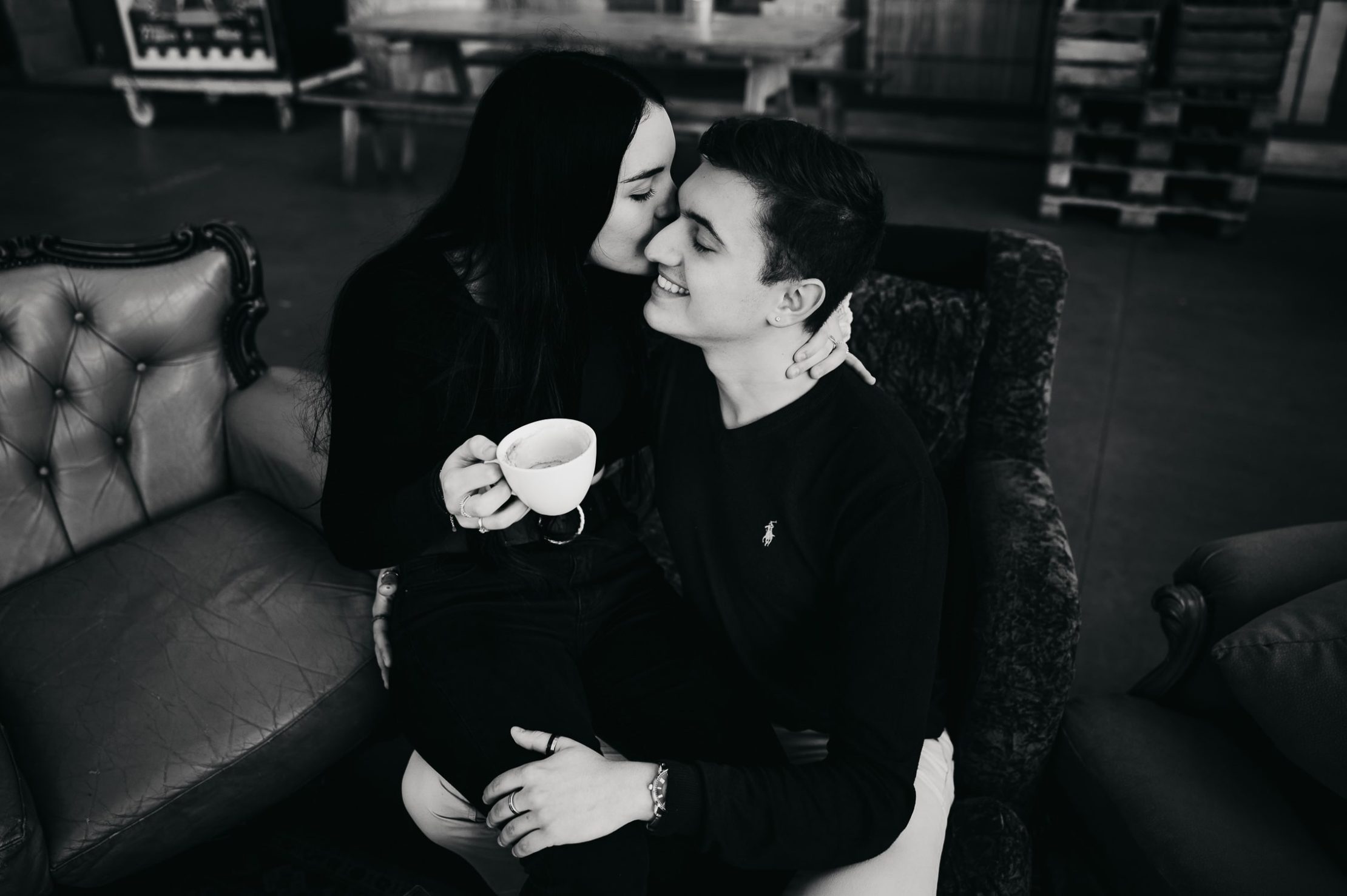Un couple, qui prend un café lors d'une séance photos couple à Bordeaux, assis sur un canapé, ambiance détente et romantique
