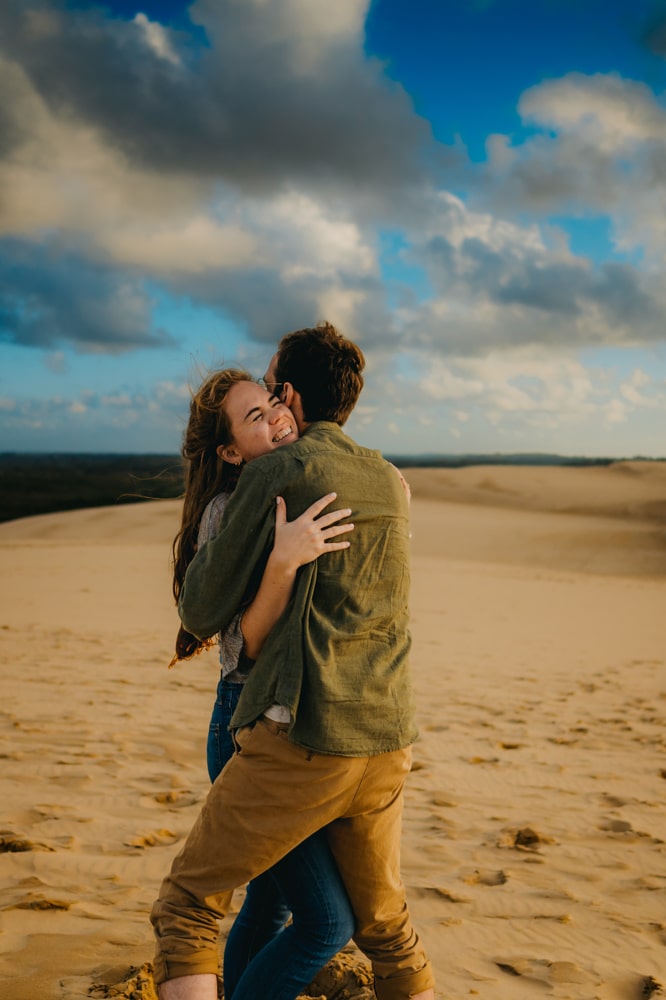 un jeune couple d'amoureux qui s'enlace avec passion sur le sable de la dune du pilat