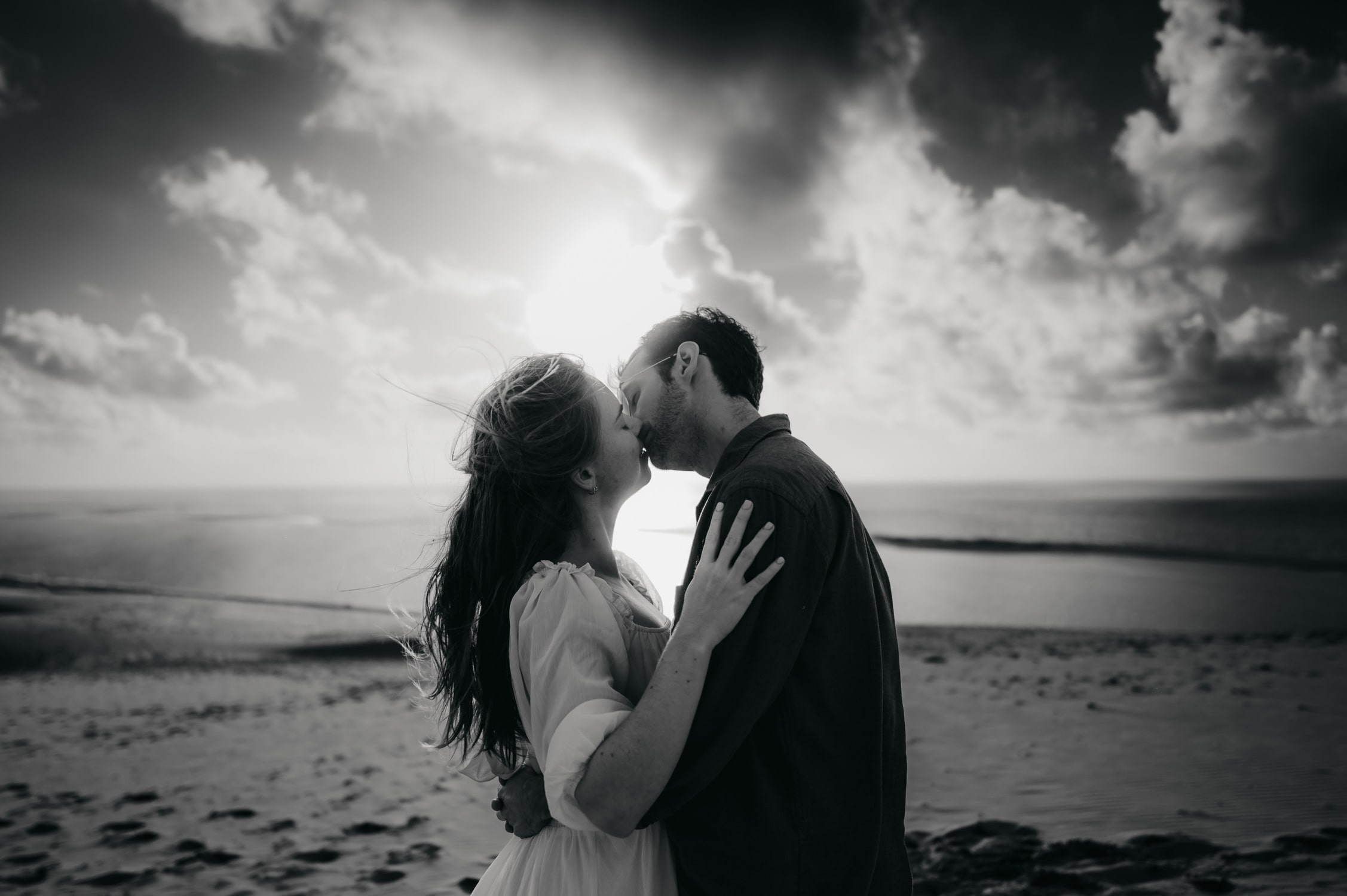 Une photographe couple à Arcachon qui fige un moment, une embrassade sensuelle d'un jeune couple en haut de la dune du pilat