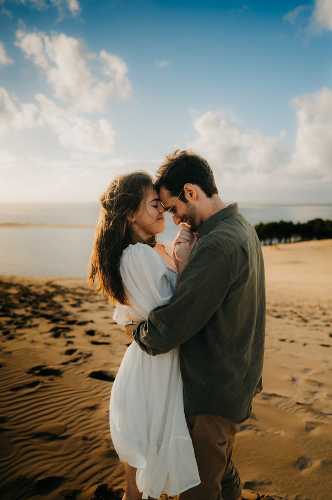 Séance photos couple à la dune du pilat, avec une photographe de Bordeaux, regard complice et gestes sensuelles