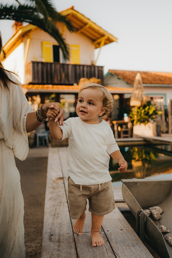 Lino qui tient la main de sa maman lors d'une balade au cap ferret