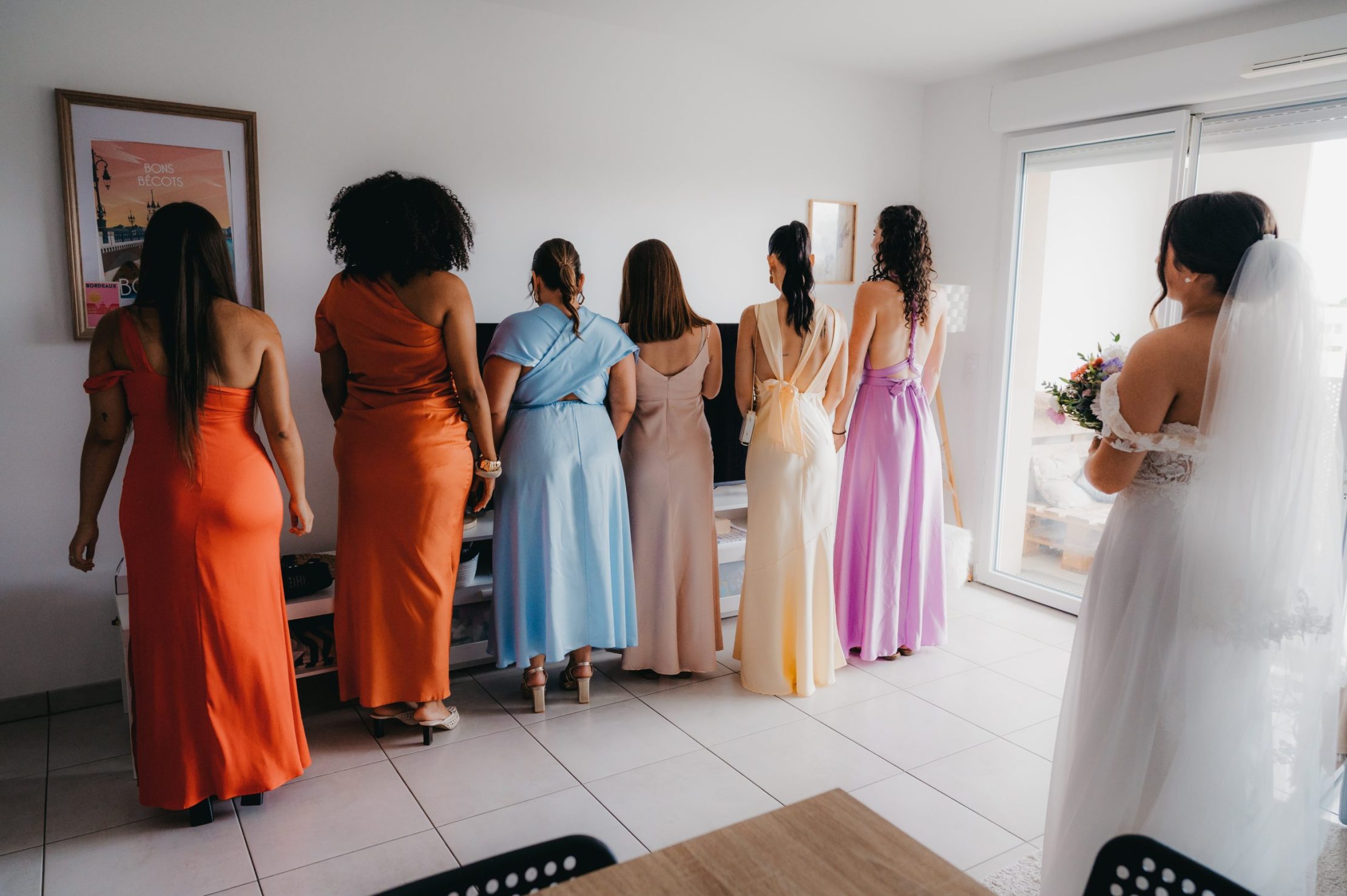 les demoiselles d'honneur de dos qui attendant sagement de découvrir la mariée dans sa robe