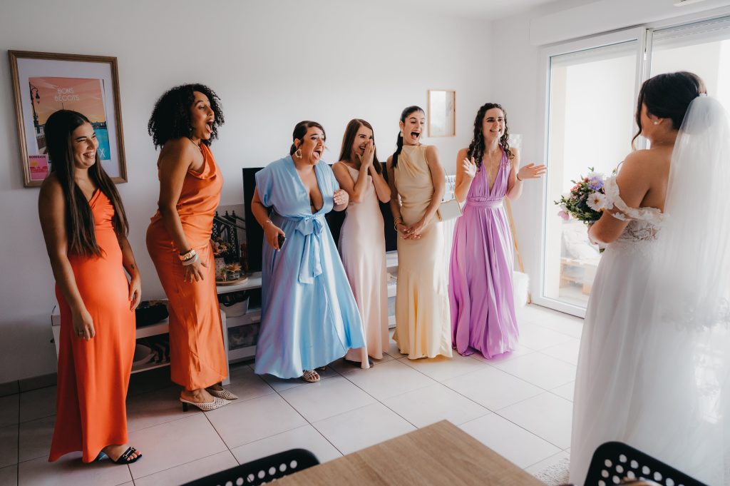 les demoiselles d'honneur qui se retournent pour découvrir la mariée dans sa robe