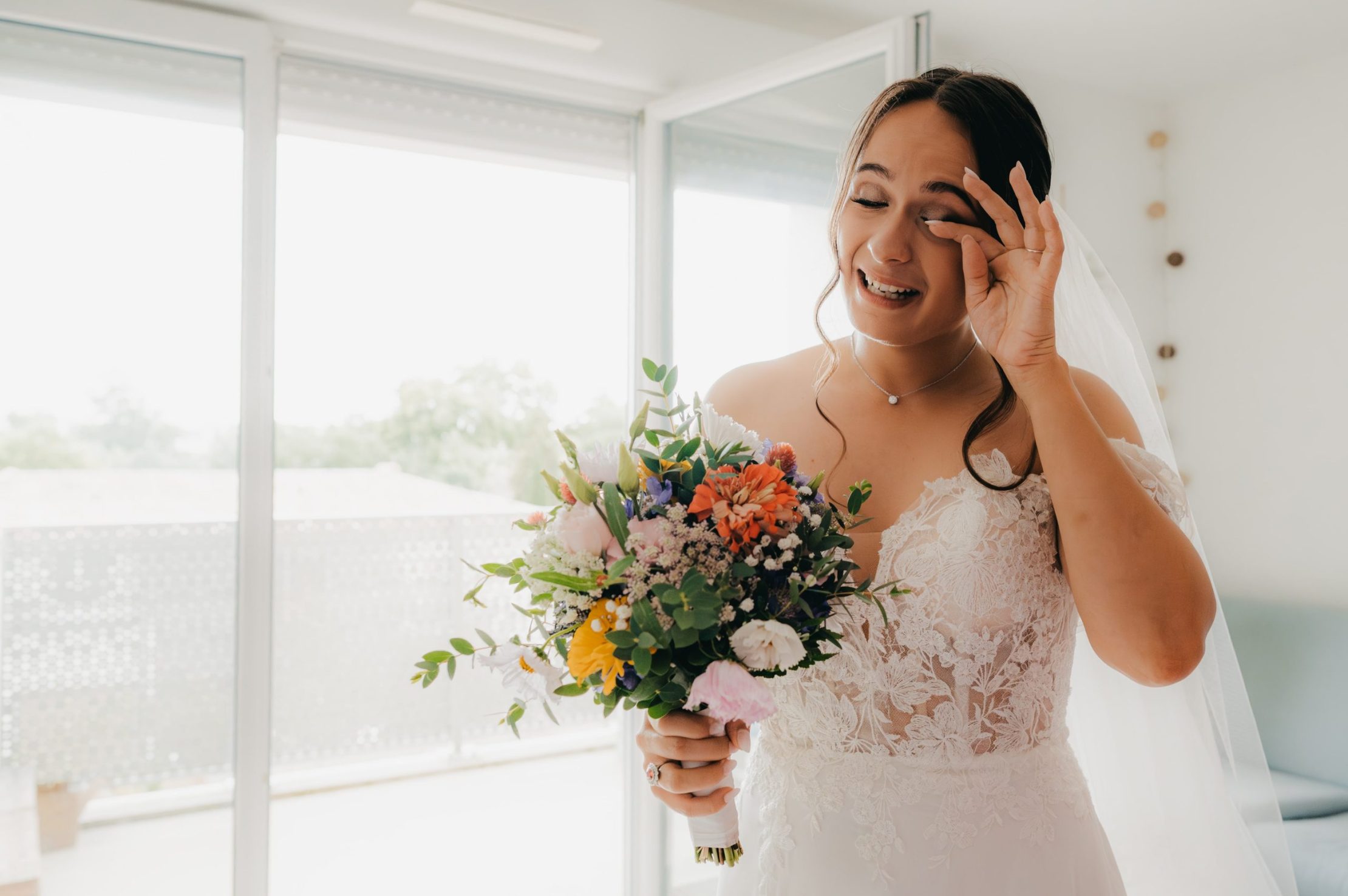 la mariée émue par la réaction de ses demoiselles d'honneur lors de la découverte de sa robe