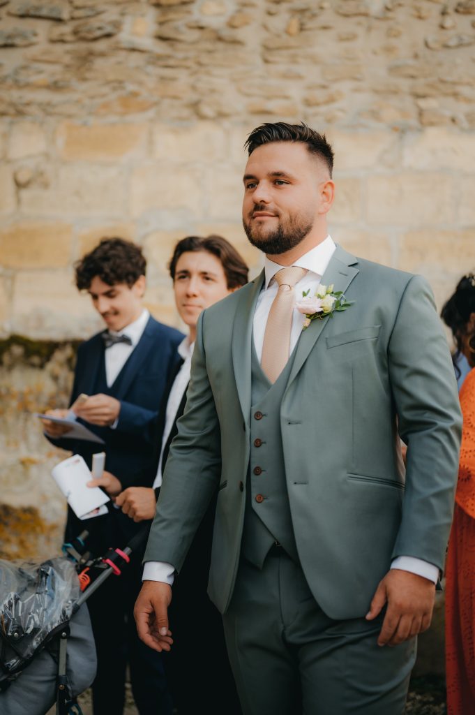 le marié qui accueille les invités devant l'église