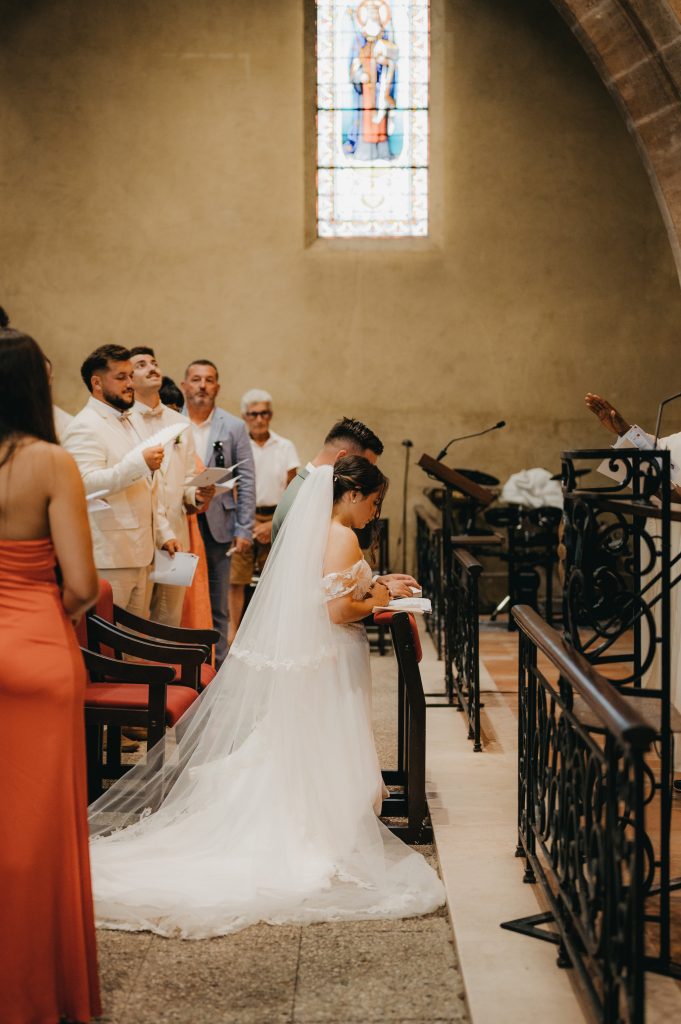 les mariés à genou dans l'église qui récitent leur prière