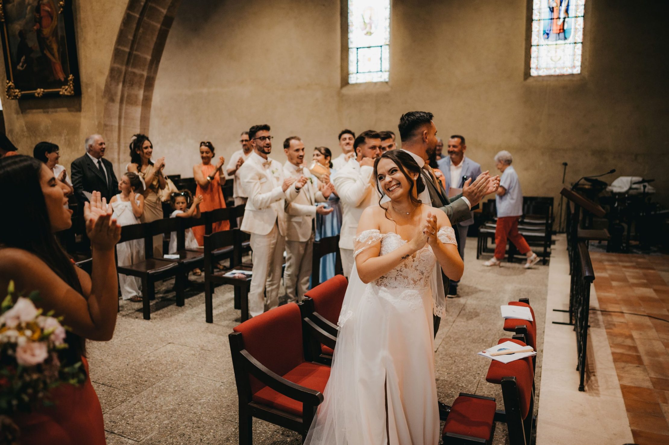 la mariée qui applaudit et se retourne pour regarder tout les invités de son mariage