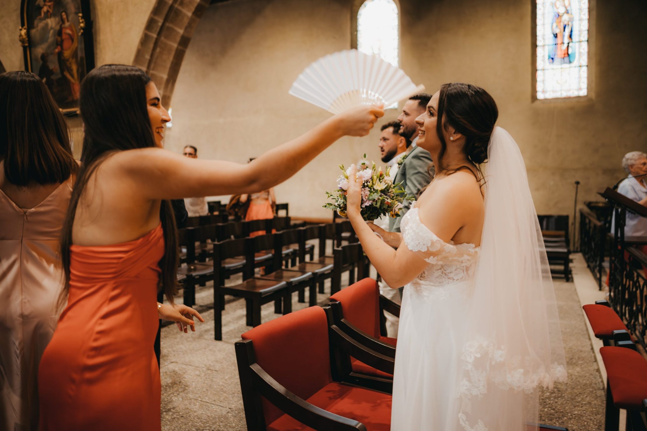 la témoin qui agite l'éventail devant le visage de la mariée pour la raffraîchir
