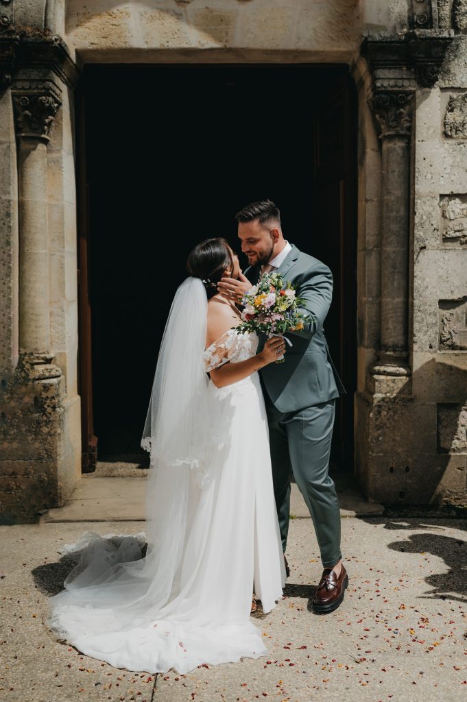 les mariés se regardant tendrement à la sortie de l'église