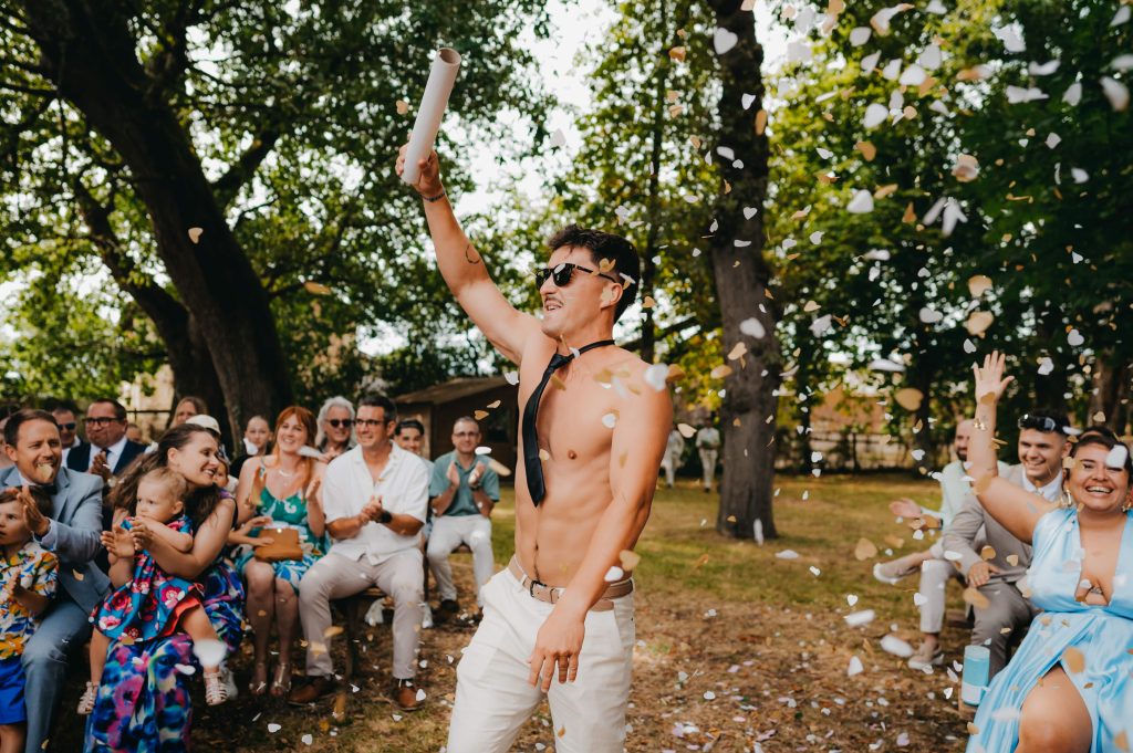 portrait d'un garçon d'honneur heureux de jeter des confettis