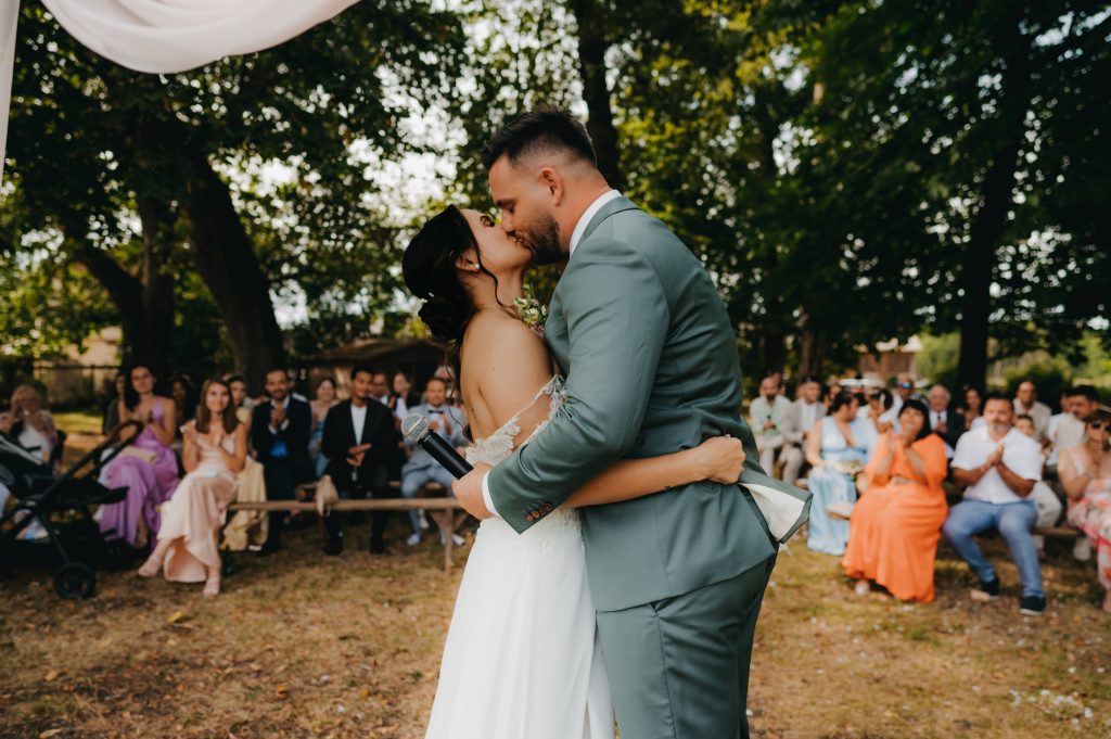 les mariés qui s'échangent un bisou après la lecture de leurs discours