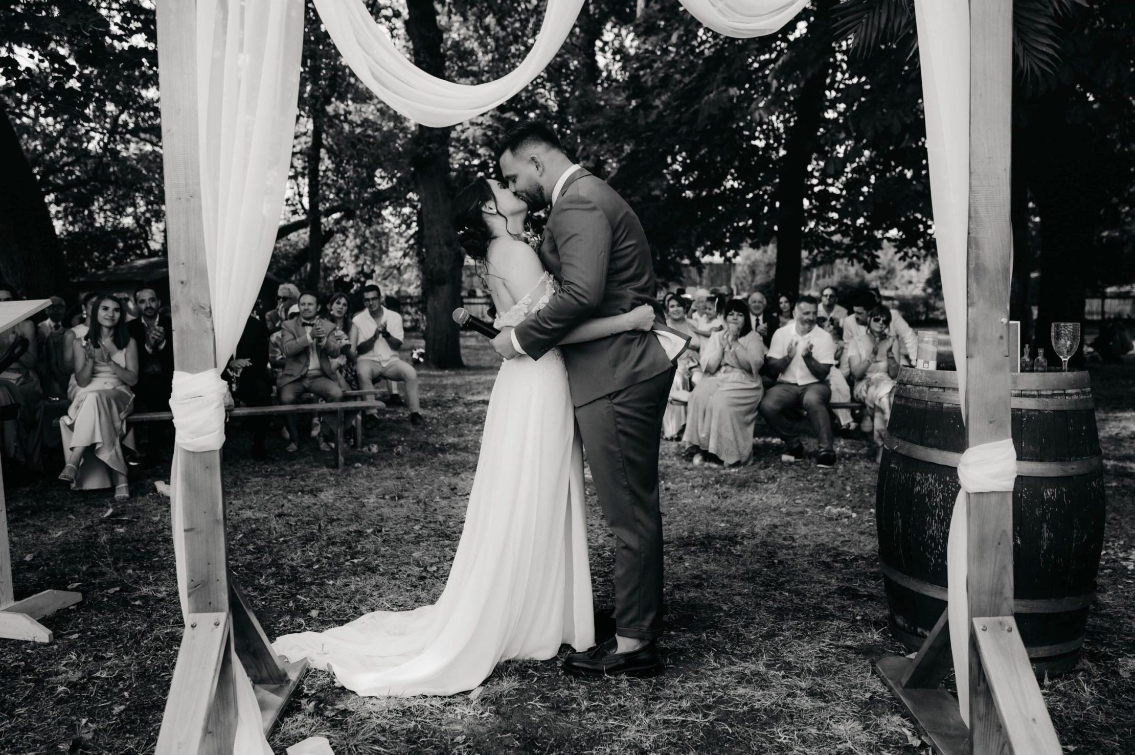 les mariés qui s'embrassent tendrement devant leurs invités
