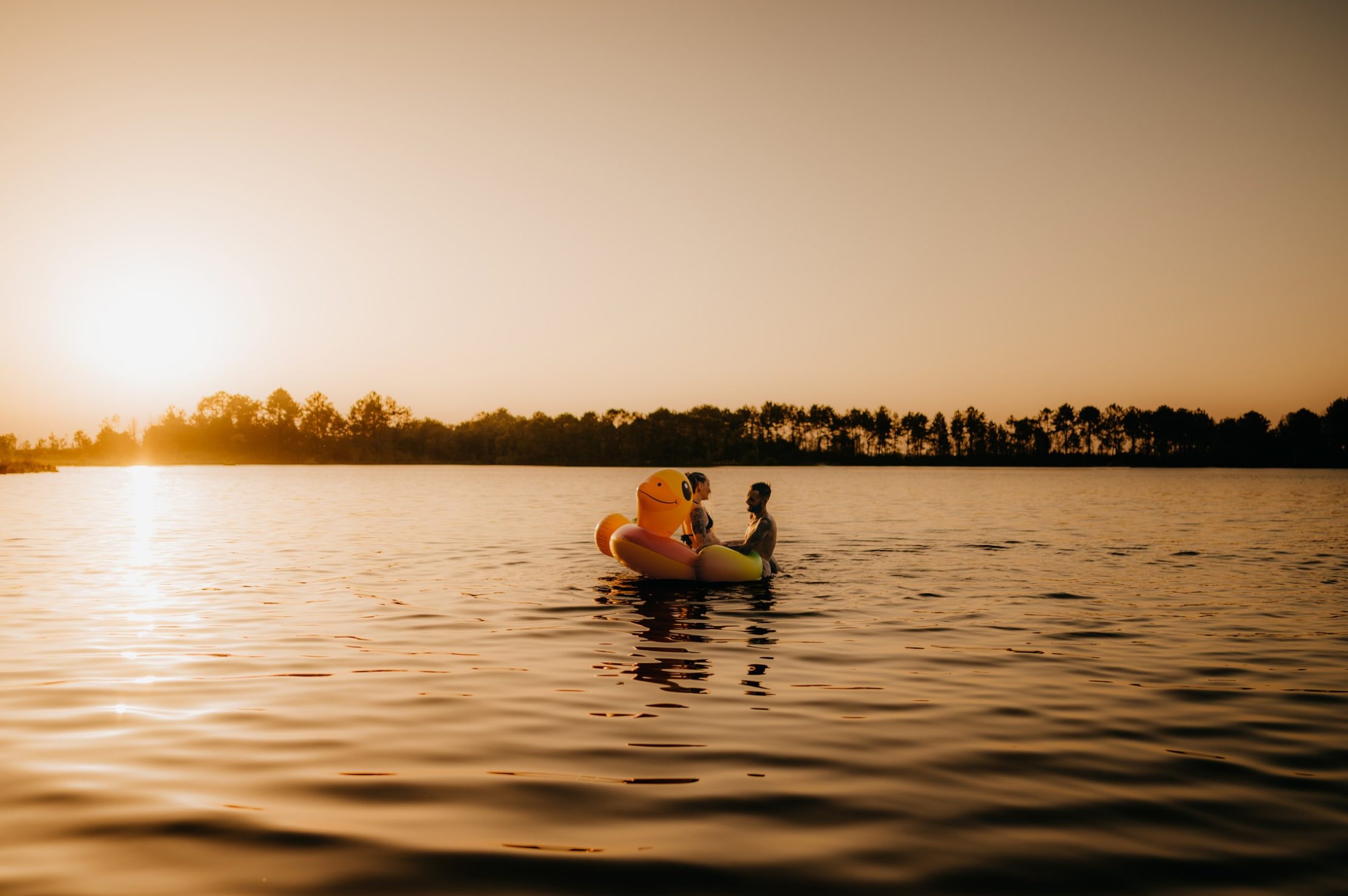 Séance photo de couple sur une grande bouée en forme de canard au lac d’Hostens