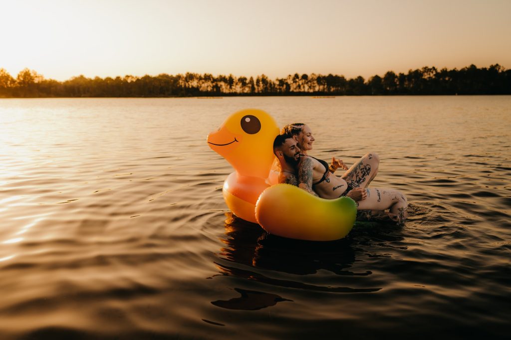 Couple souriant sur une bouée géante en canard au lac d’Hostens