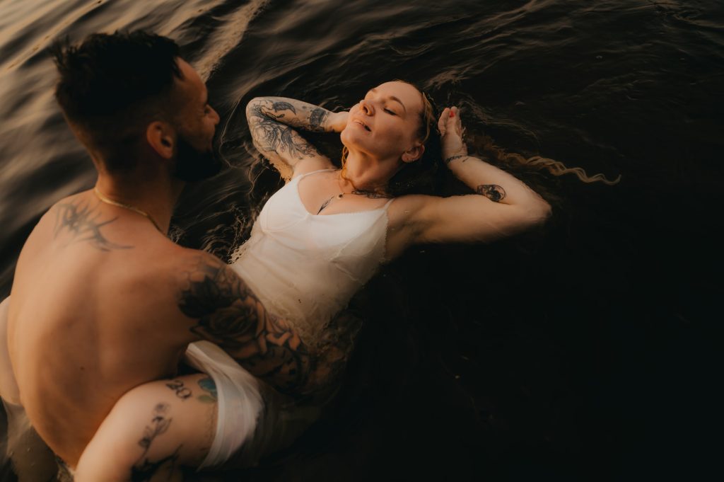 Jeune femme avec une robe blanche, détendue, qui flotte sur le dos, dans l'eau