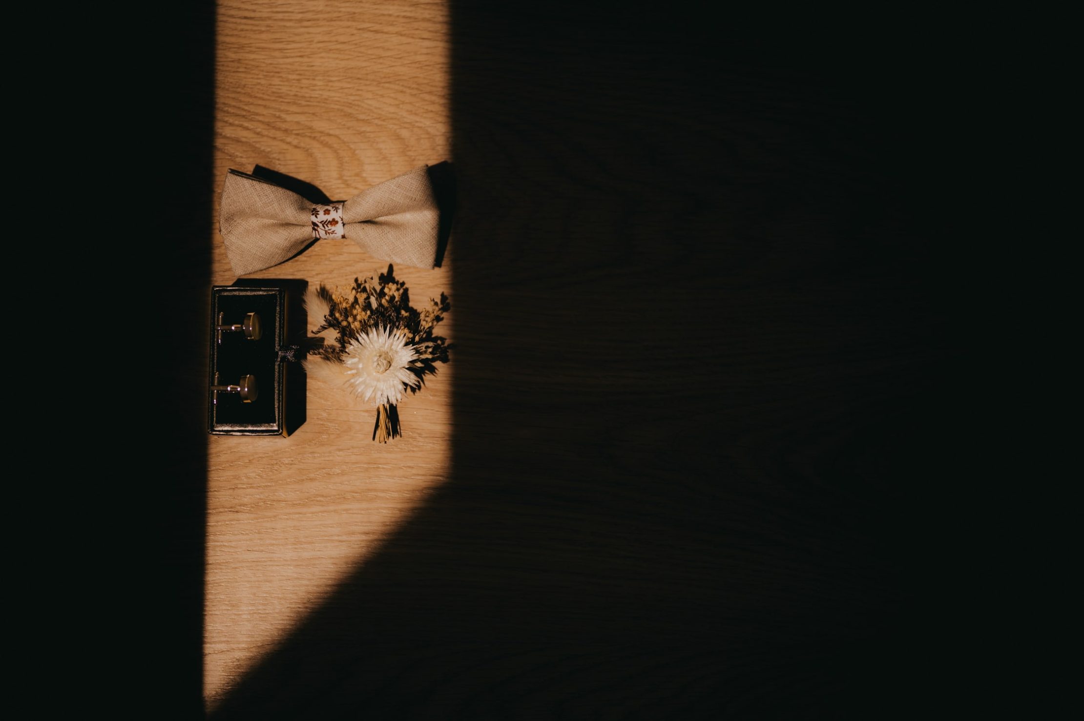 photo détail lors d'un mariage d'un noeud papillon et d'un parfum lors des préparatifs du marié