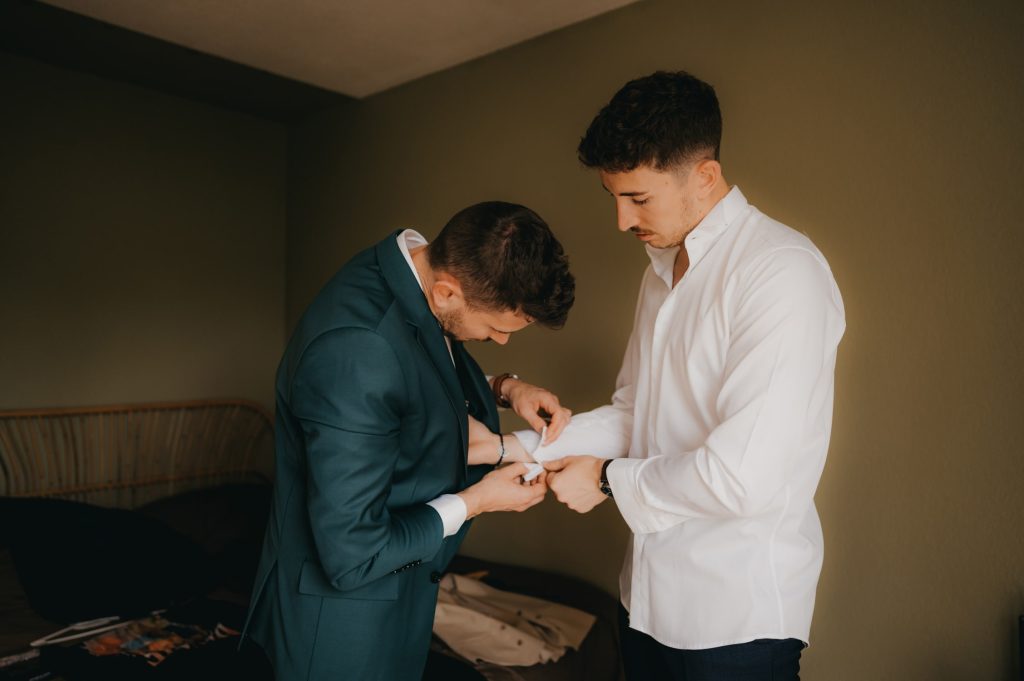 un jeune homme qui enfile un costume