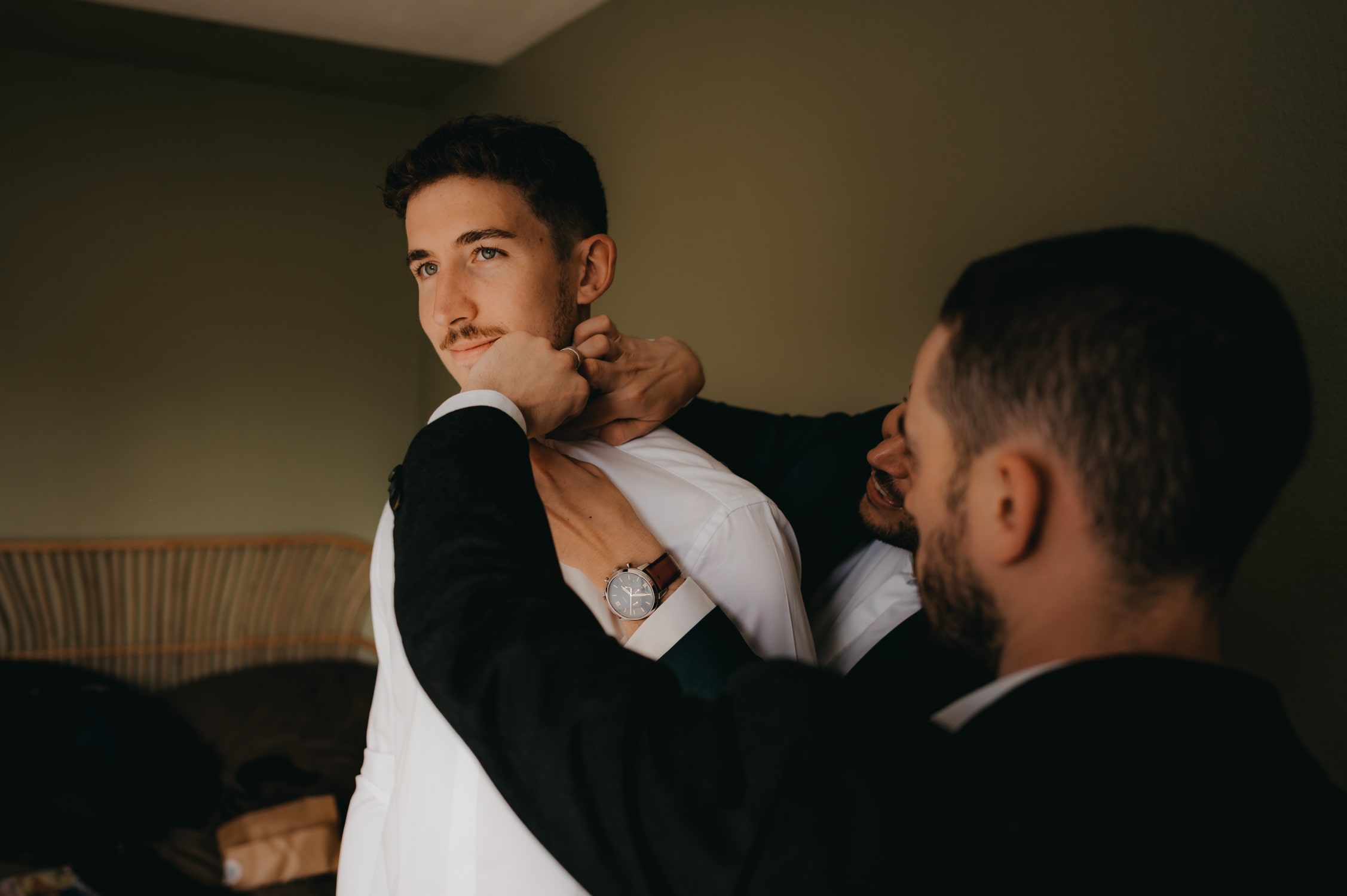 un jeune homme qui met un noeud papillon autour de son cou