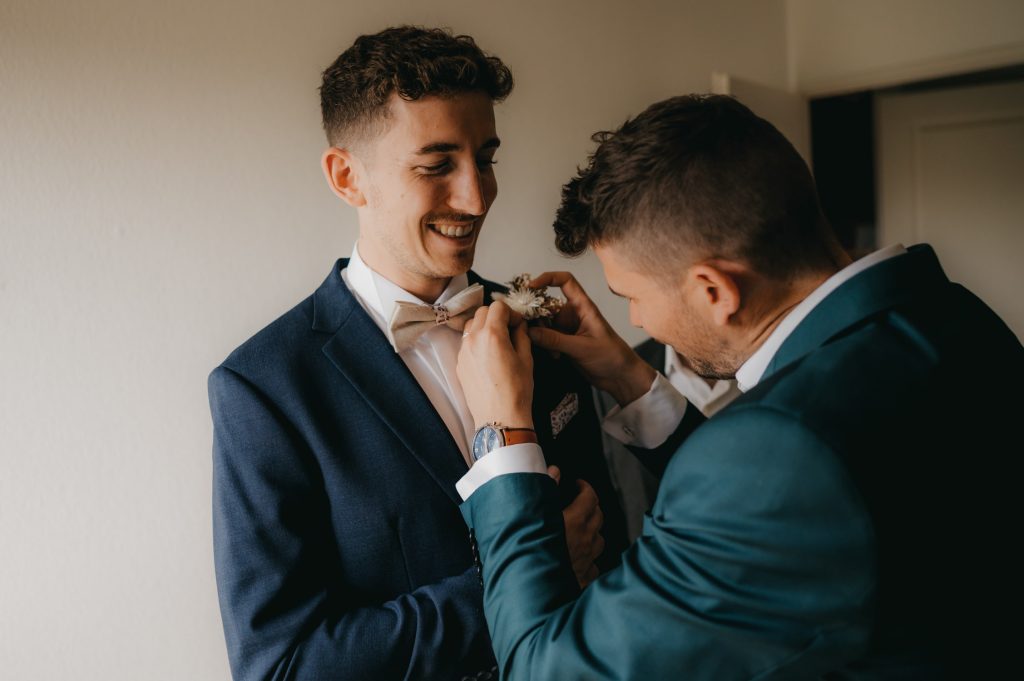 deux jeunes hommes qui s'habillent pour aller à un mariage