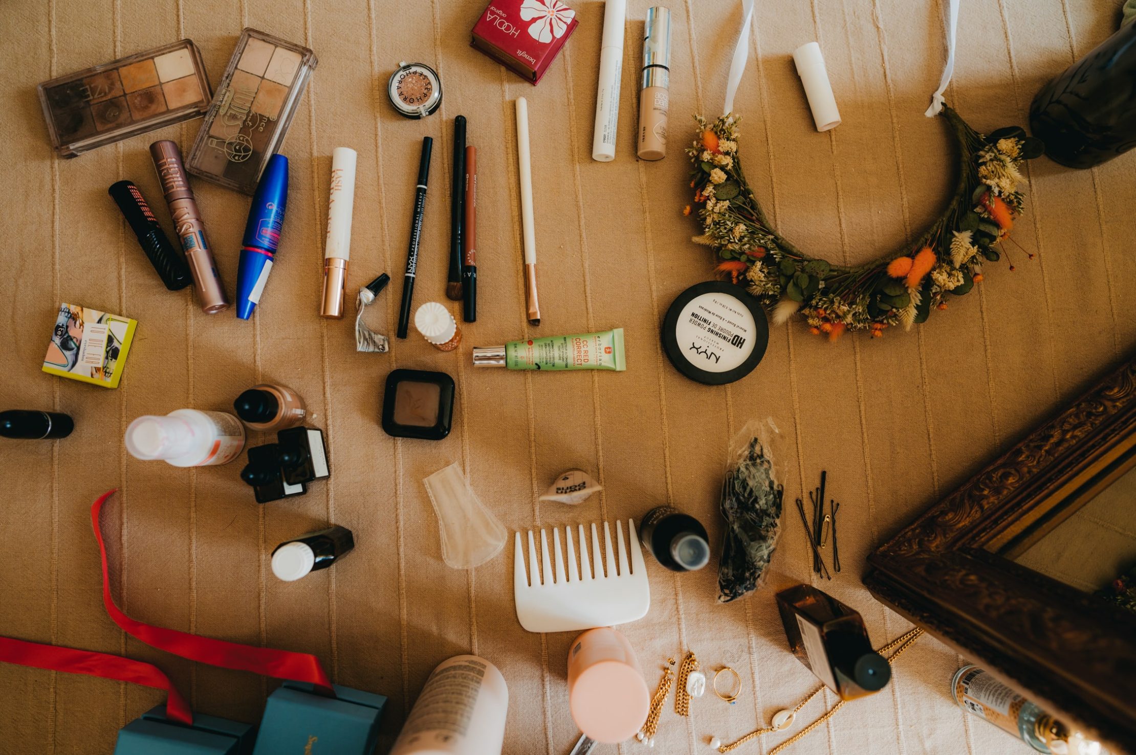 photo de plusieurs outils de maquillage posé sur une couverture sur un canapé