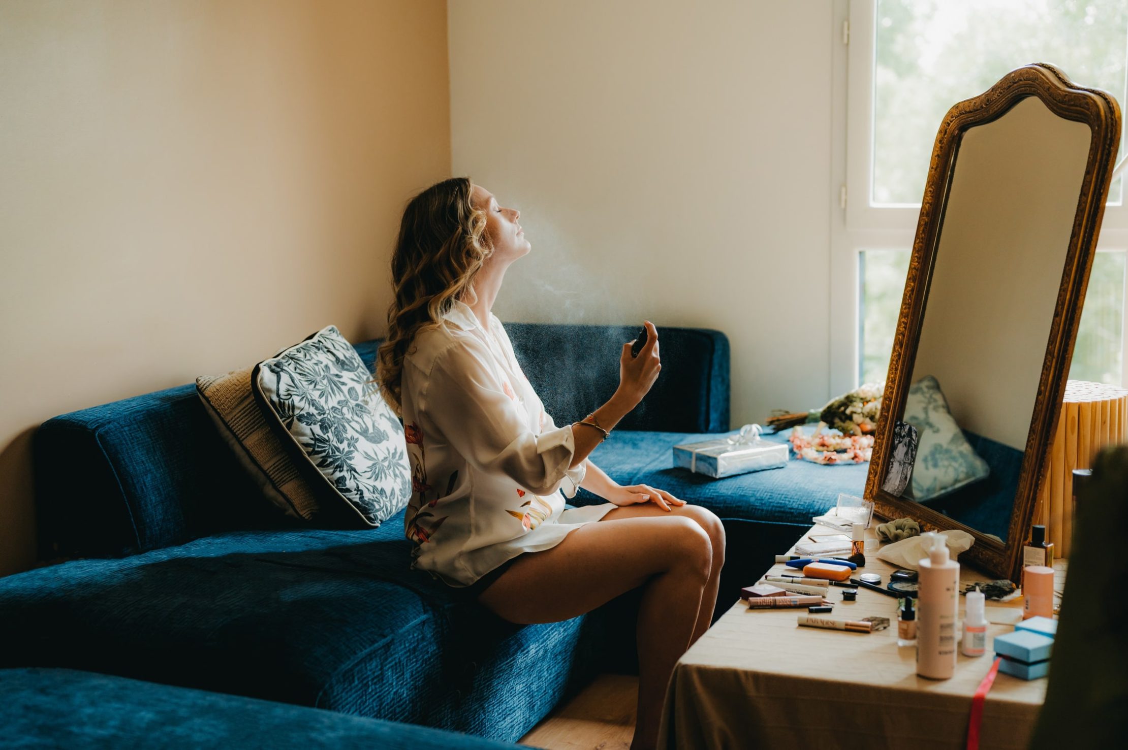une jeune femme qui se parfume dans son salon