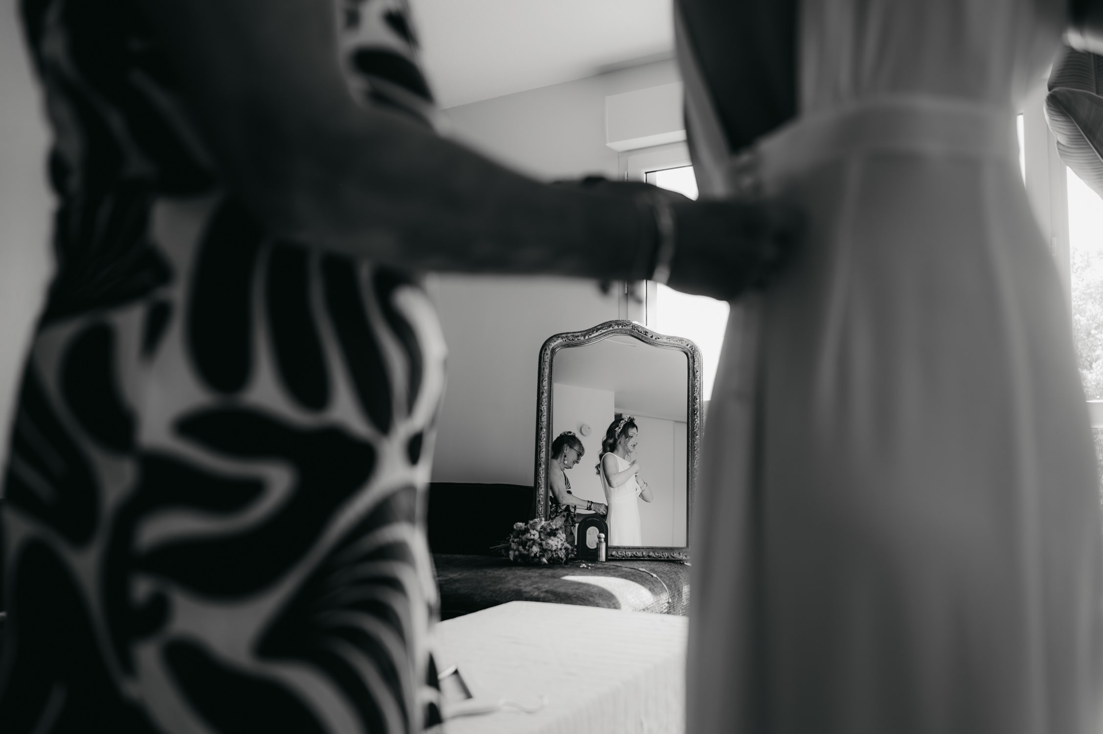 une maman qui habille sa fille pour un mariage