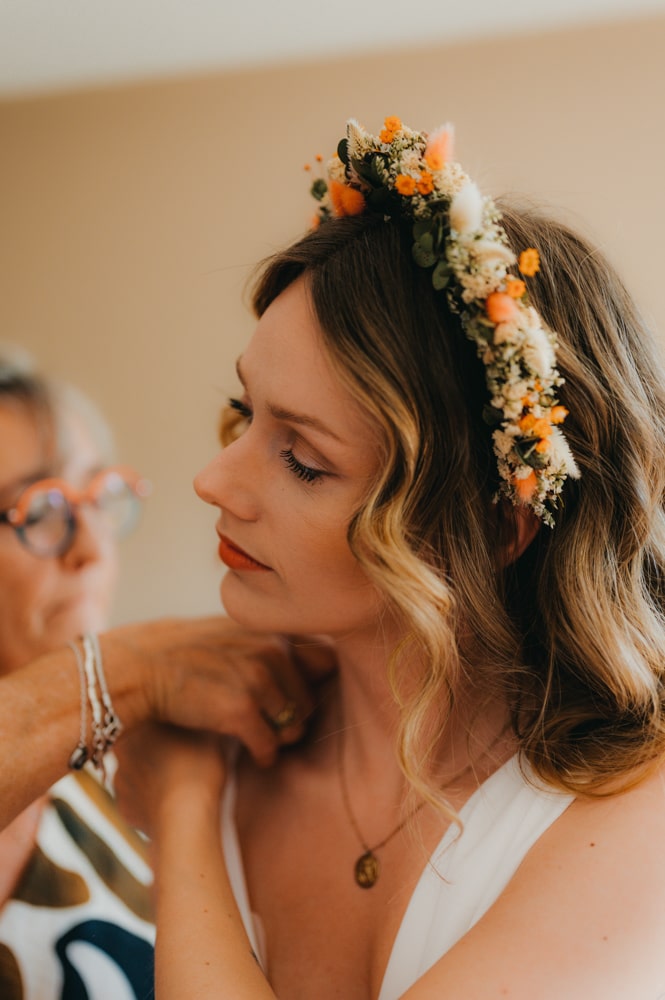 jeune femme qui enfile sa robe de mariée