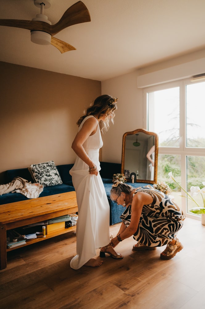 une maman qui met les chaussures à sa fille dans le salon