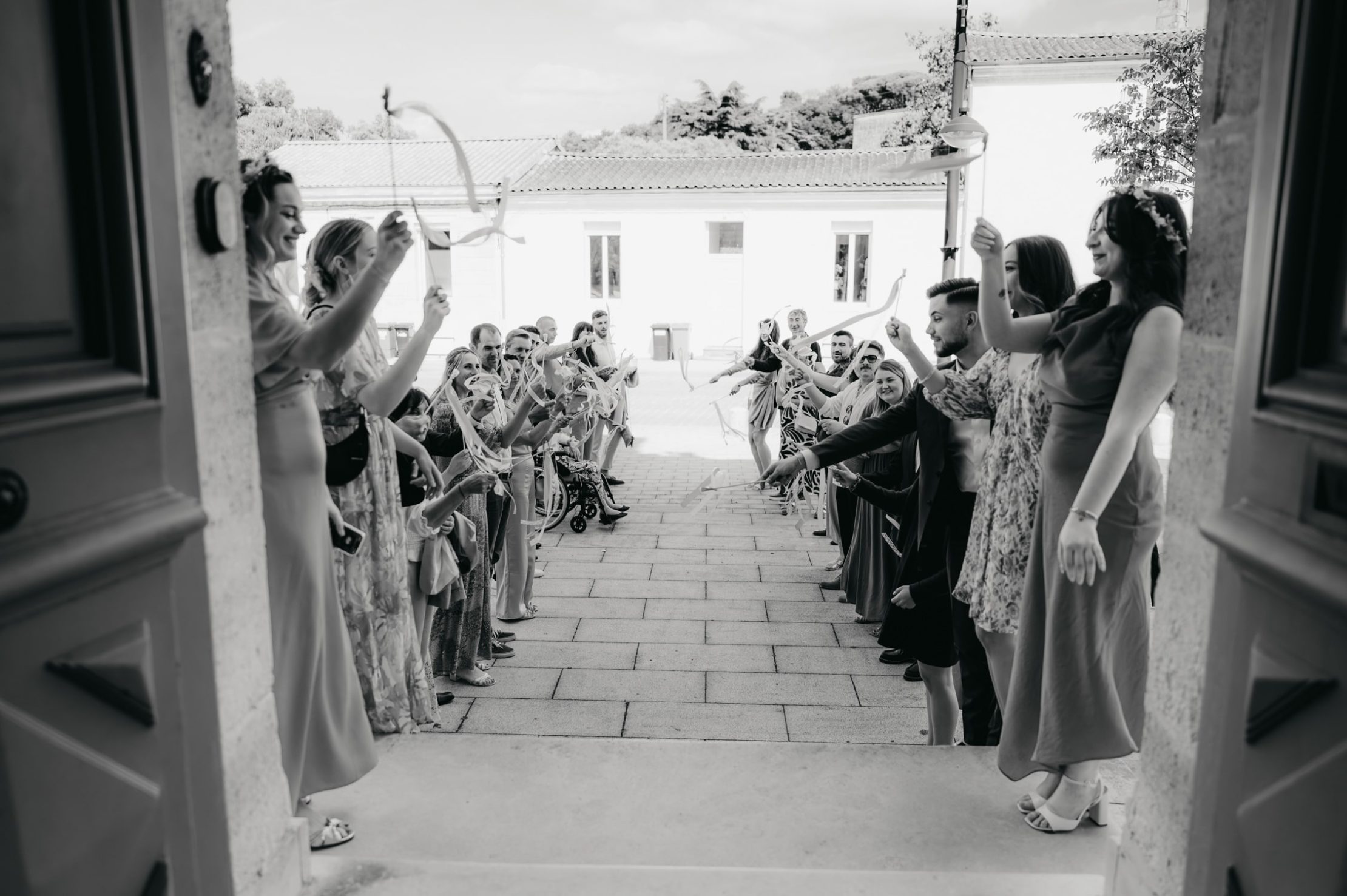 une allée d'invités en sortie de mairie qui attendent les mariés pour leur sortie
