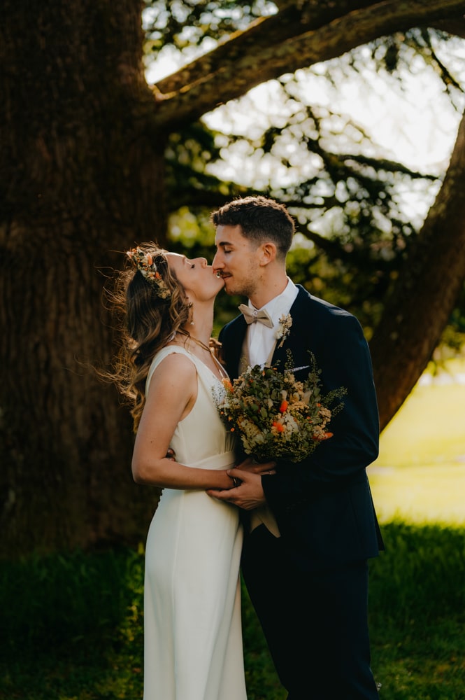 Photo romantique des mariés sous les arbres