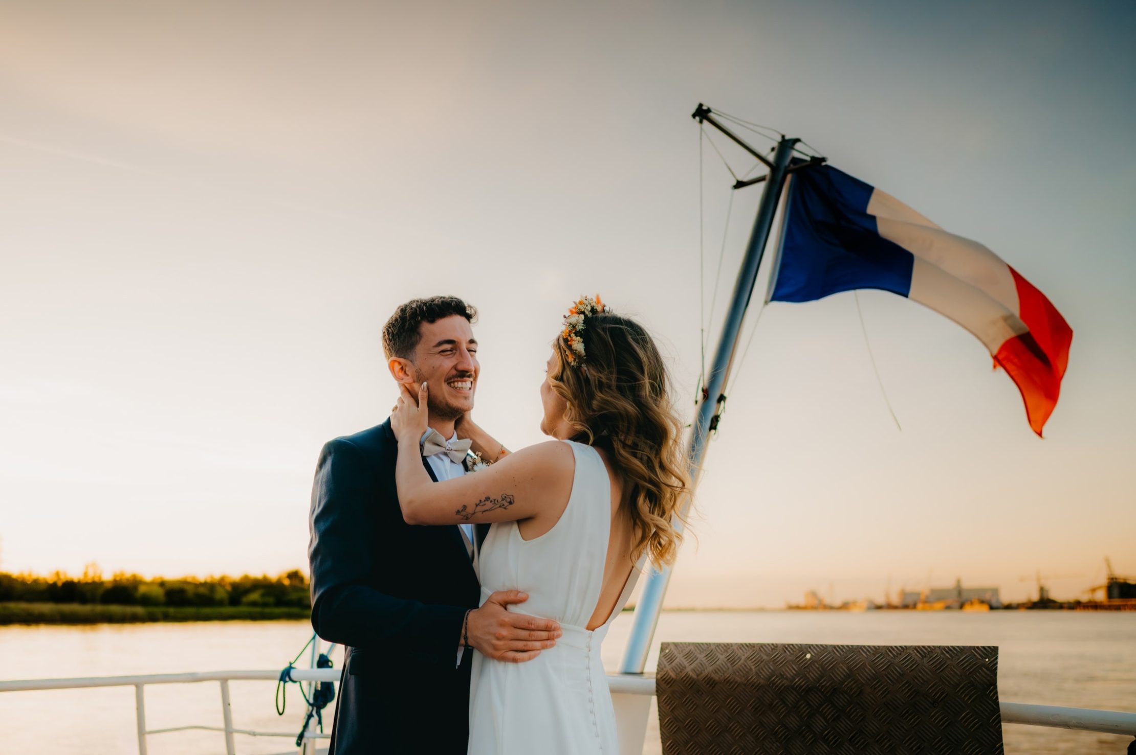 les mariés devant le couché de soleil, sur la péniche qui navigue sur la Garonne