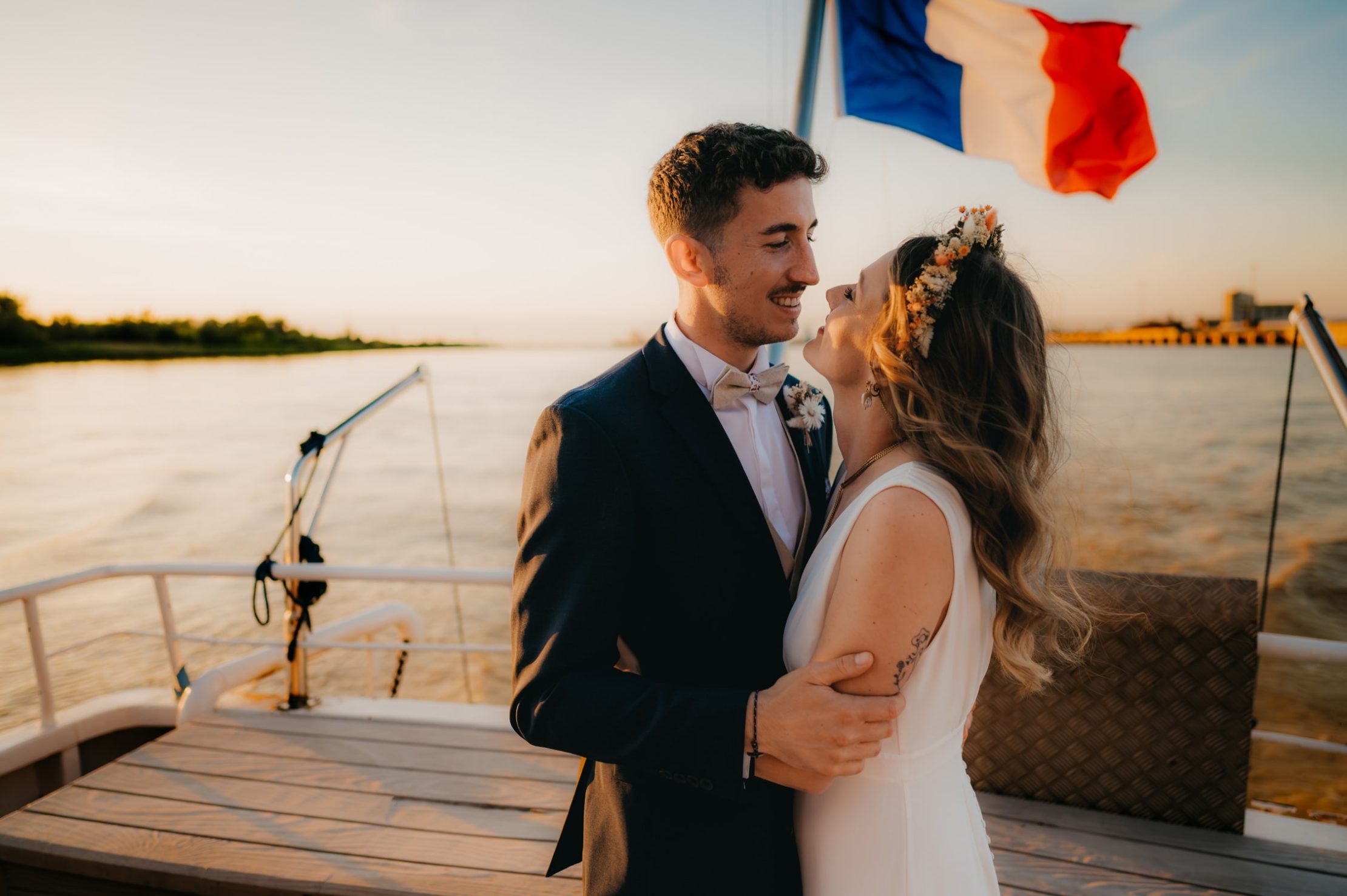 Blanche et Guillaume souriants sur la péniche au coucher du soleil