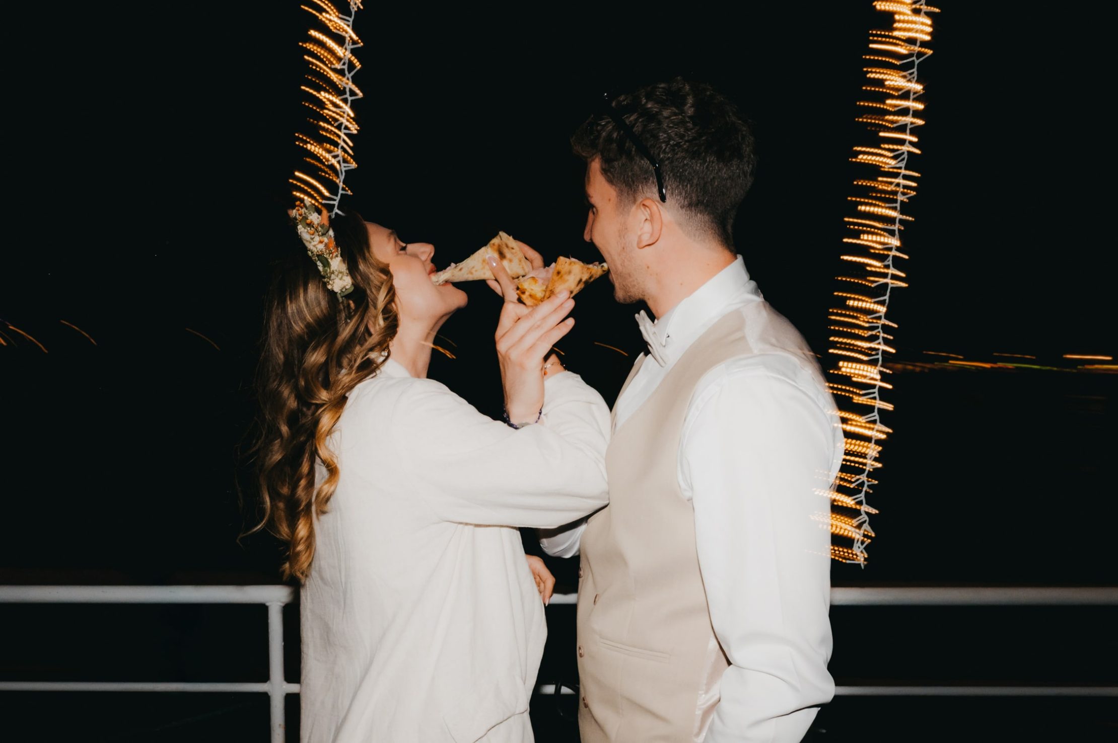 les mariés qui partagent un bout de pizza