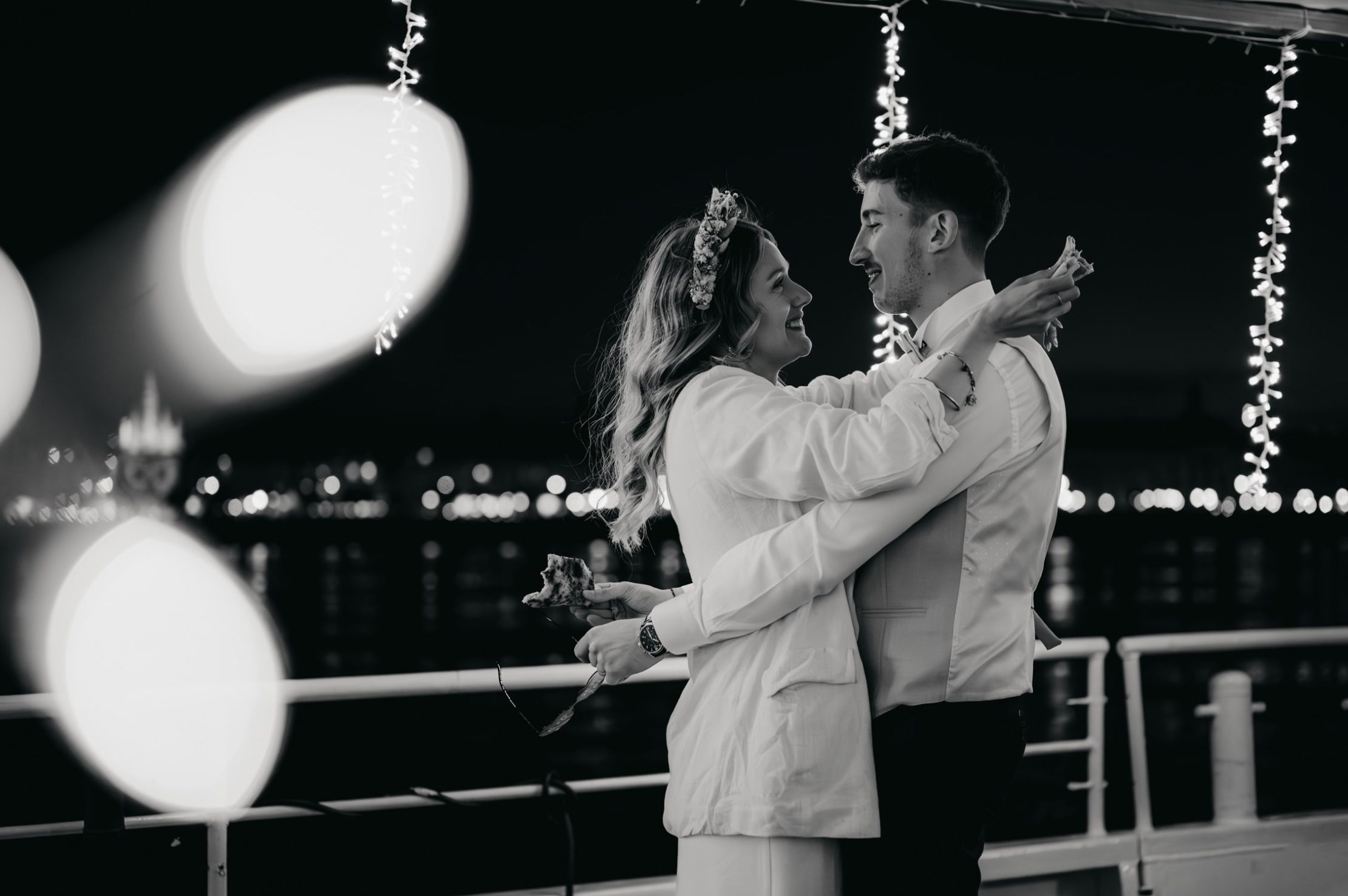 les mariés qui s'enlacent tout en mangeant un bout de pizza