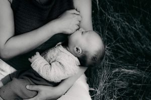 Le bébé tête auprès de sa maman pendant la séance photo naissance à Bordeaux, Gironde.