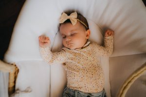 Le bébé dort profondément sur le dos avec les bras écartés. Un moment paisible de la vraie vie capturé par L'instant par Phé, photographe bébé Bordeaux et Gironde.