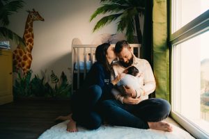 Les parents sont assis par terre dans la chambre de bébé. Un moment de douceur capturé par L'instant par Phé, photographe bébé Bordeaux et Gironde.