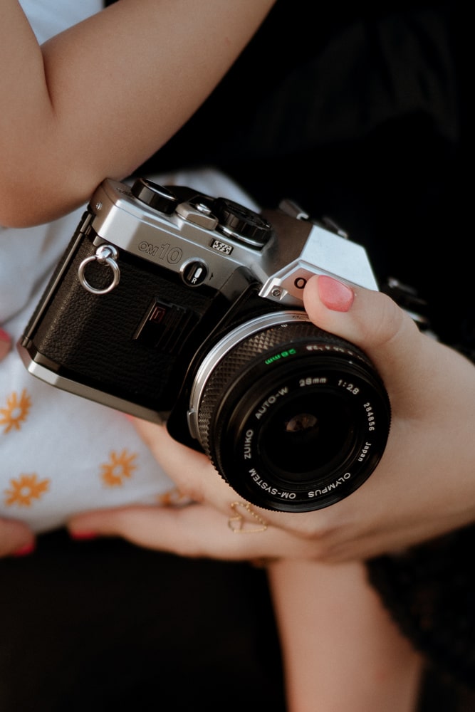 La photographe bordeaux & gironde tient un appareil photo dans sa main.