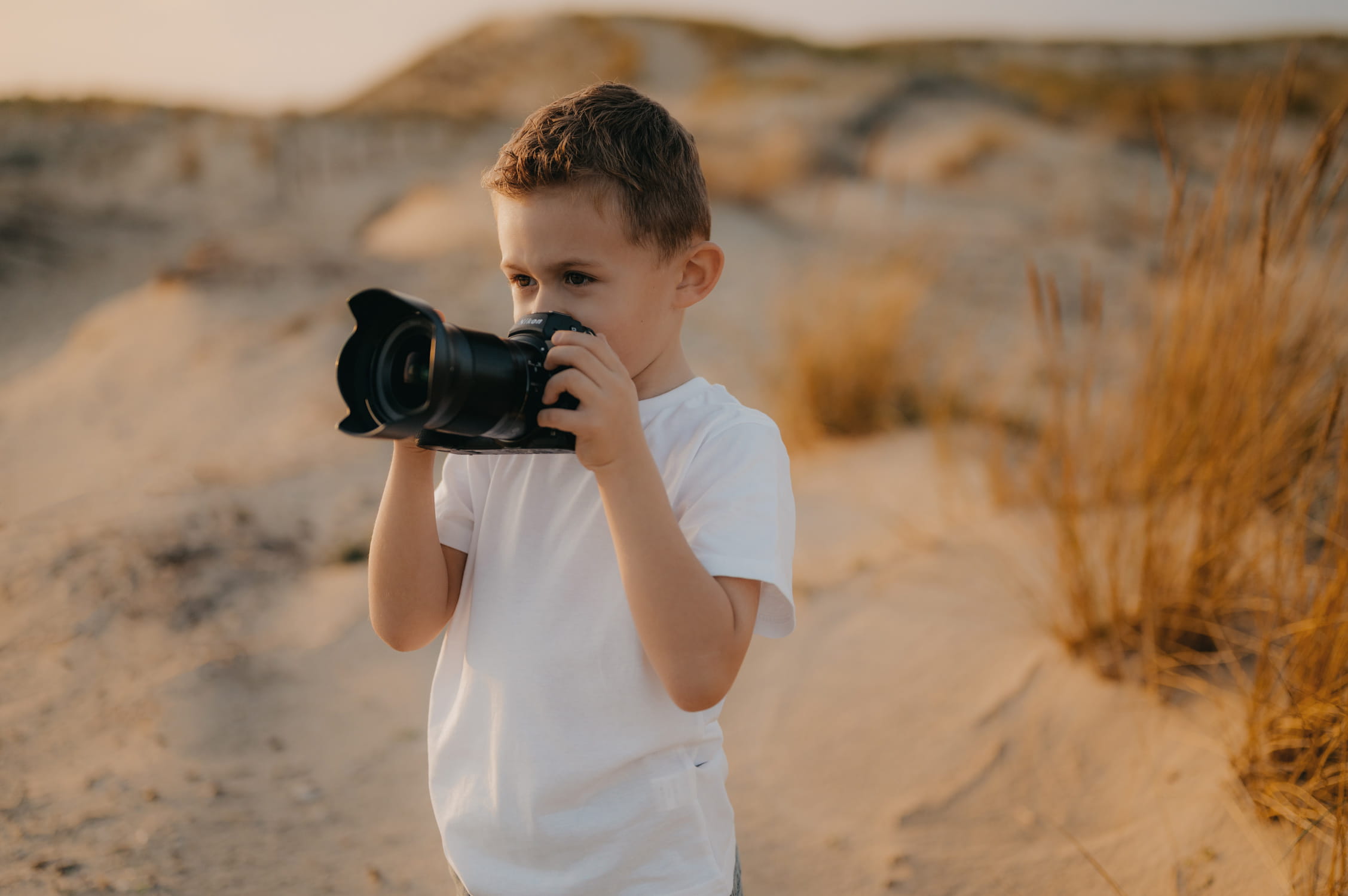 un enfant avec un appareil photo au bord de mer