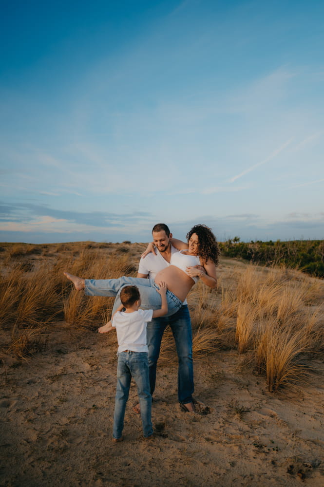 Famille jouant dans les dunes au coucher du soleil, séance photo lifestyle naturelle