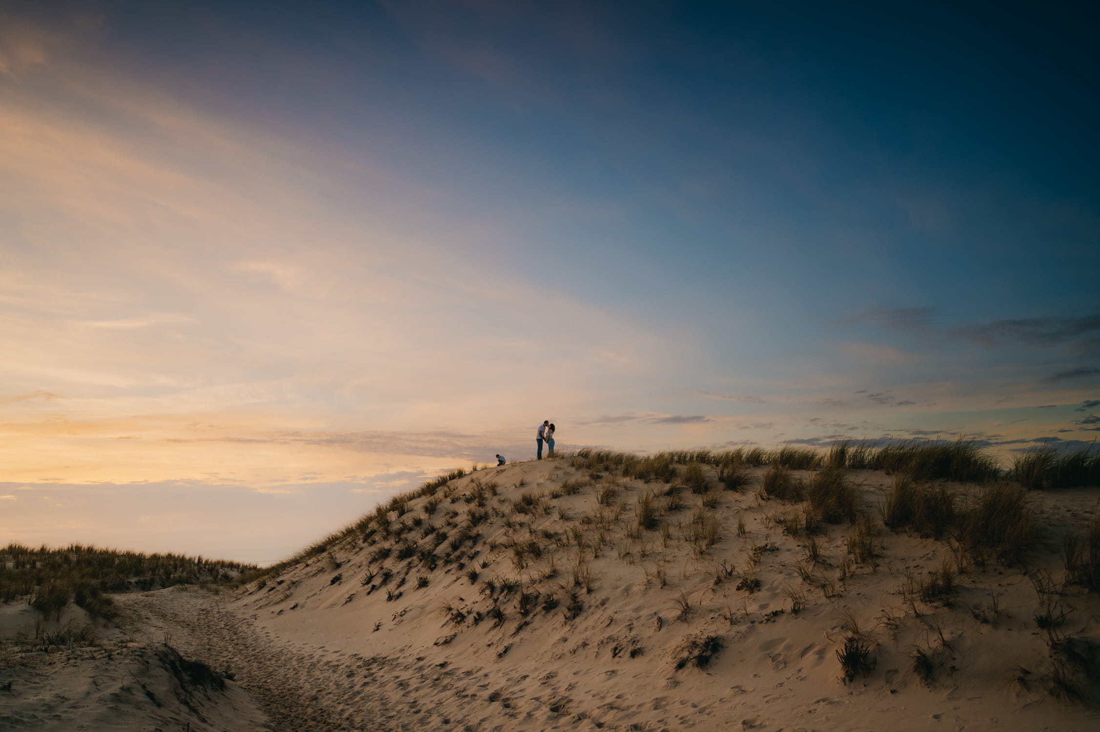 Couple attendant un bébé lors d’une séance photo sur la plage