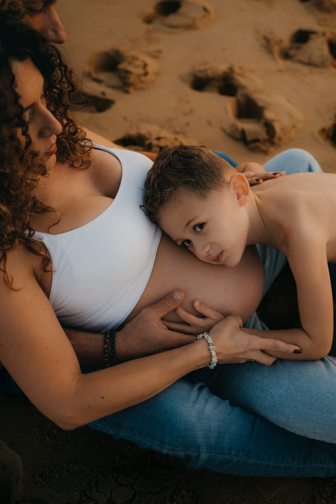 un petit garçon qui enlace le ventre rond de sa maman