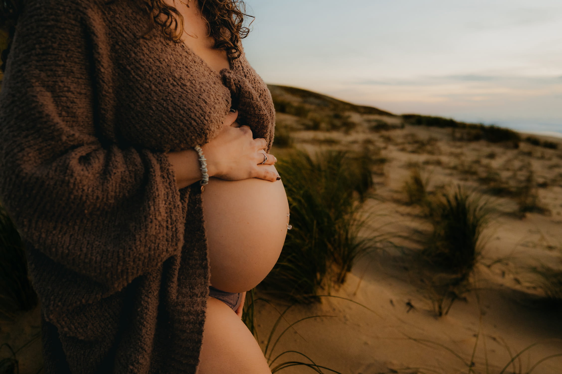 Moment tendre autour du ventre de grossesse en pleine nature