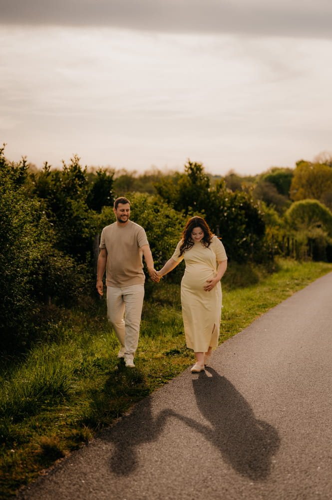 Couple profitant de la lumière dorée lors d’une séance grossesse près de Camarsac
